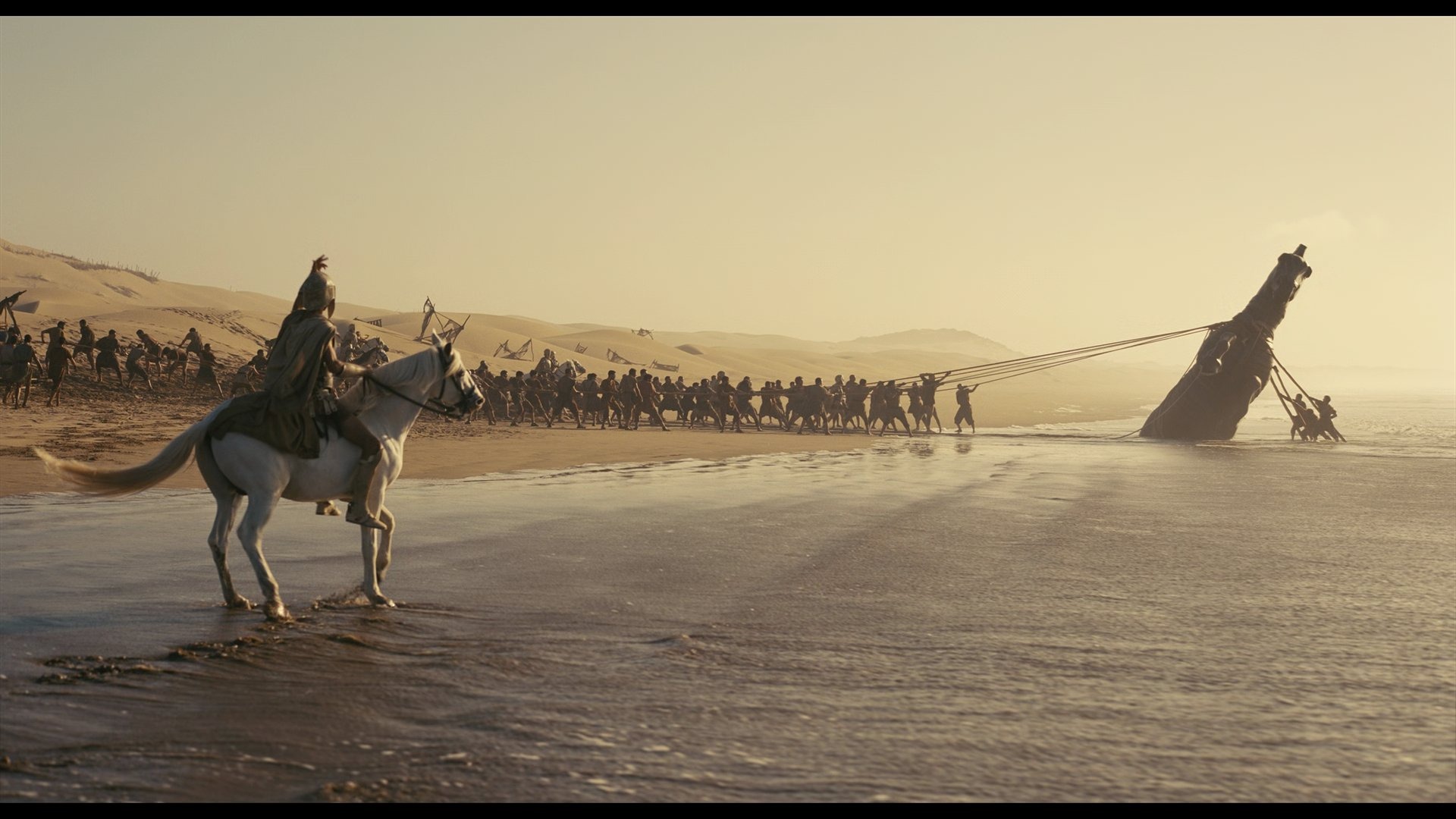 The Trojan Horse being dragged onto the beach at sunset